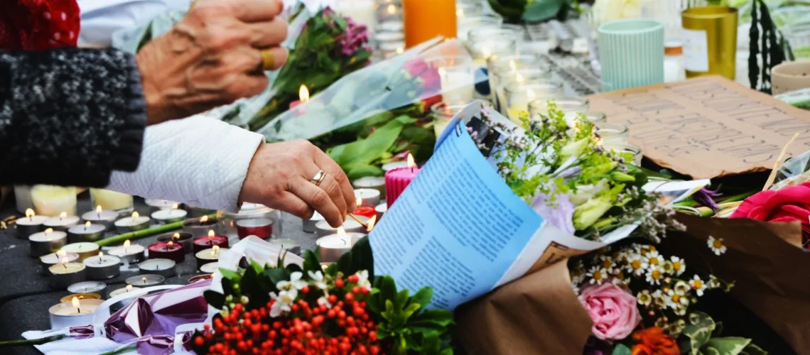 Scène touchante d'un mémorial avec des fleurs et des bougies.