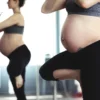 Femme enceinte faisant du yoga devant un miroir, favorisant santé et bien-être.