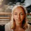 Portrait serein d'une fille blonde avec un éclairage naturel doux et un arrière-plan flou.