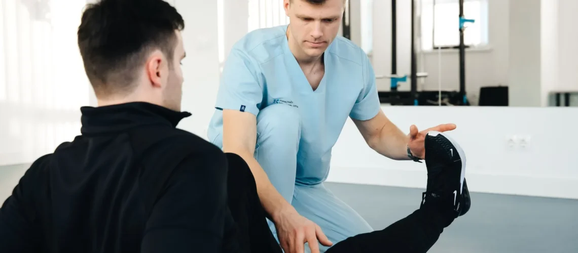 Un kinésithérapeute aidant un patient à faire des exercices de jambe lors d'une séance de rééducation en clinique