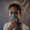 Portrait d'un enfant utilisant un masque à oxygène à l'intérieur, mettant en évidence les besoins en soins de santé.