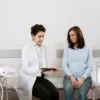 Femme enceinte en consultation avec un gynécologue dans un établissement médical.