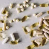 Diverses vitamines et compléments alimentaires sur fond de marbre, photographiés à plat.