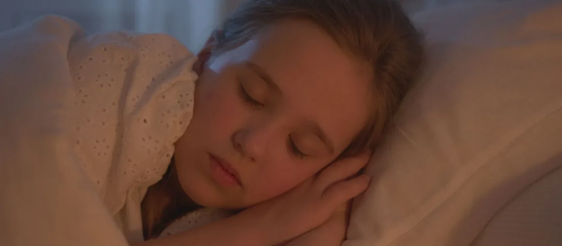 Une jeune fille dormant paisiblement à l'intérieur, baignée d'une lumière chaude.