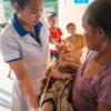 Professionnel de santé aidant une mère avec son nourrisson dans une clinique rurale au Laos.