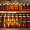 Des dizaines de pots de miel sur des étagères dans un cadre rustique créent une présentation chaleureuse et accueillante.