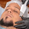 Un homme reçoit un soin du visage avec un équipement de cosmétologie avancé.