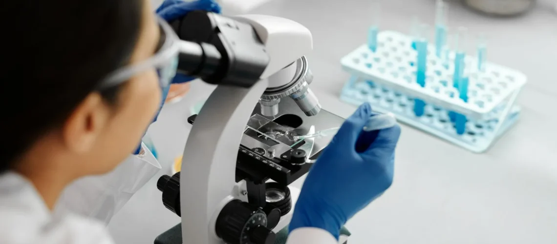 Scientifique menant des recherches en laboratoire à l'aide d'un microscope et d'une pipette