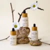 Flacons de sérum à l'acide hyaluronique bio avec fleurs et pierres sur fond neutre