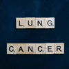 Lettres de Scrabble formant « cancer du poumon » sur fond sombre, symbole de sensibilisation.