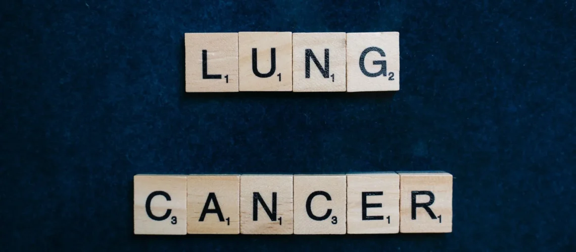 Lettres de Scrabble formant « cancer du poumon » sur fond sombre, symbole de sensibilisation.