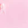 Un ruban rose sur fond rose pâle symbolisant la sensibilisation au cancer du sein et la solidarité.