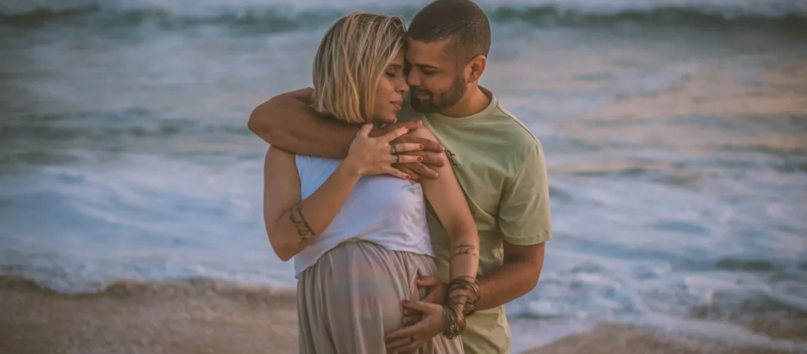 Un couple amoureux s'enlace sur une plage sereine, mettant en avant l'intimité et l'attente.