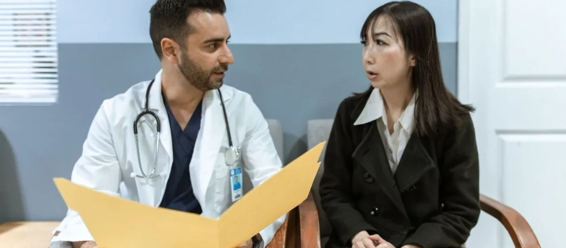 Un professionnel de santé consulte un patient en milieu clinique. Discussion médicale et diagnostic.