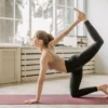 Jeune femme exécutant une posture de yoga dans un espace intérieur lumineux, incarnant bien-être et souplesse.